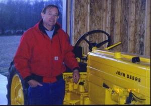 Jim McFarlane standing next to JD tractor
