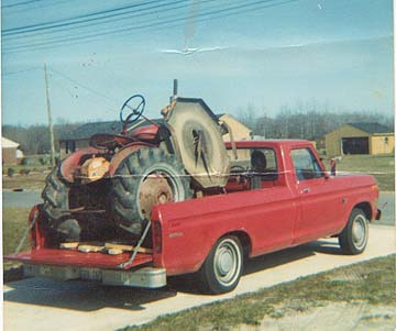 normal pickup truck wiht tractor loaded into the bed