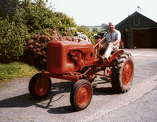 man driving freshly painted tractor