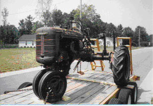 rusty tractor on trailer going to new home