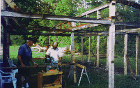two men working on skeletal structure of upright beams and crossmembers
