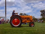 tractor is orange with rounded grill, black badge, narrow front