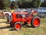 tractor is orange with rounded grill, black badge, narrow front