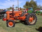 tractor is orange with rounded grill, black badge, narrow front