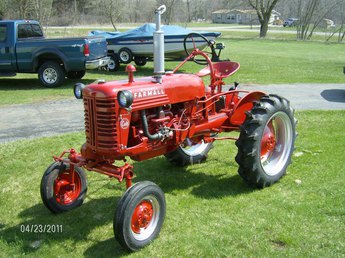 farmall cub with truck and boat in the bacground